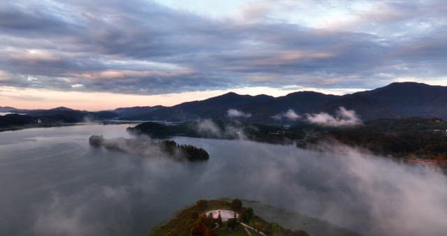 Serene river surrounded by misty mountains