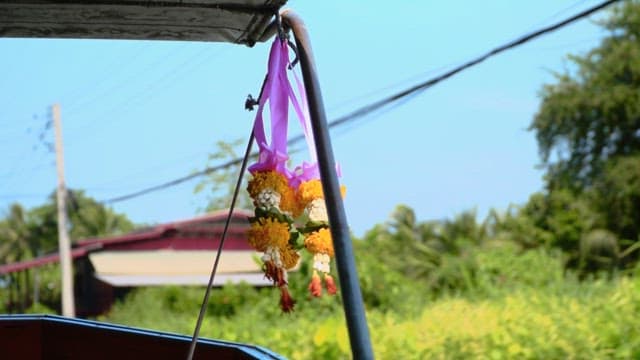 Yellow and orange marigold flower garlands hung on boat