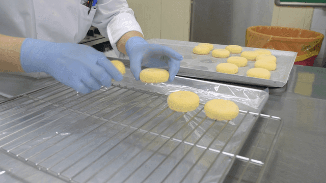 Chef arranging cookies on baking tray