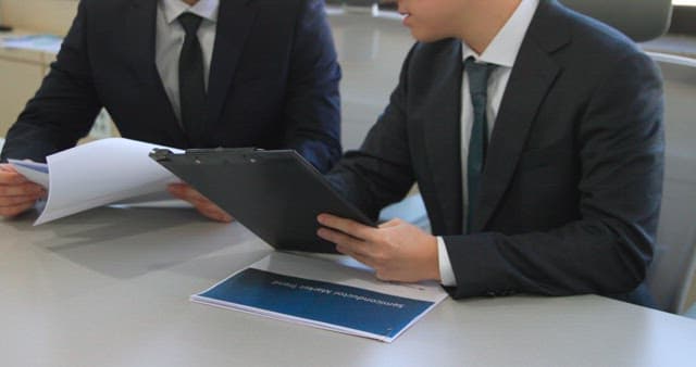 Two Professionals Reviewing Documents at a Desk