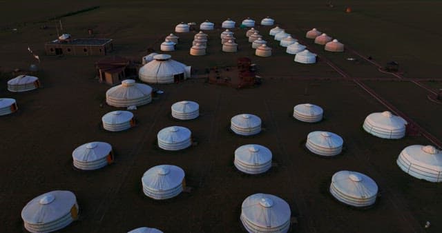 Traditional yurts in a vast open field