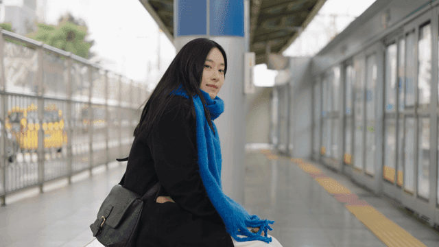 Woman waiting on a bench at a subway station