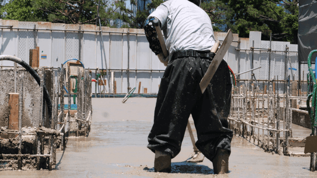 콘크리트를 고르게 하는 건설 노동자