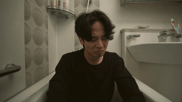 욕조에 앉아 눈물을 흘리는 남성