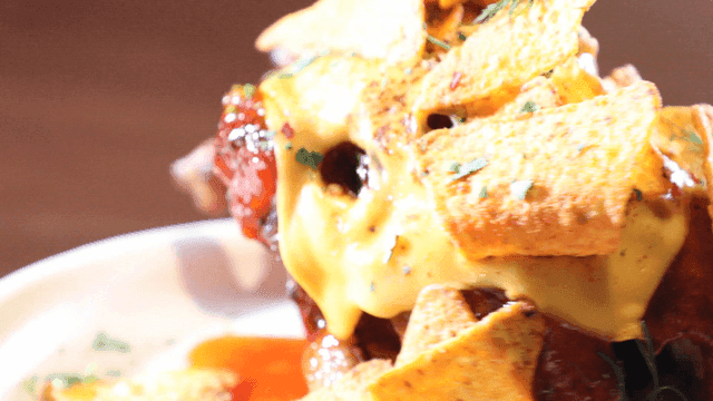 Nacho wood-fired whole chicken covered in sauce and cheese