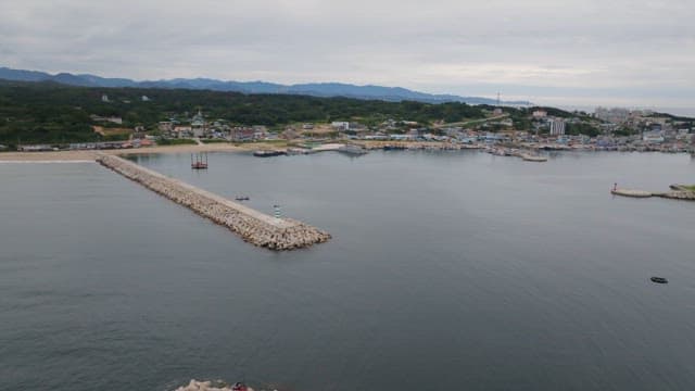 긴 부두와 잔잔한 바다가 있는 해안 마을