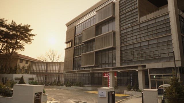 황혼에 주차장이 있는 현대적인 건물 앞