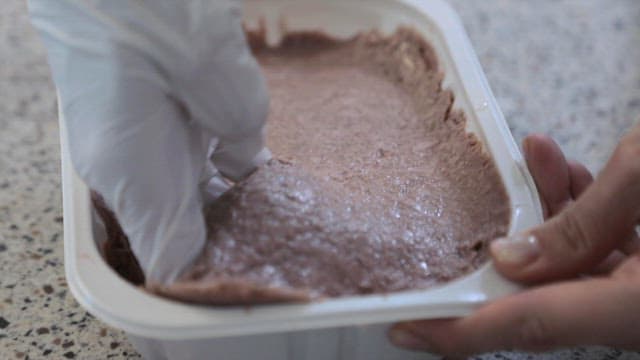 플라스틱 용기에 담아둔 고기를 채소와 섞는 모습