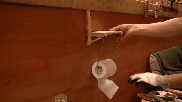 수제 나무 화장지 홀더 위치를 조정하는 사람