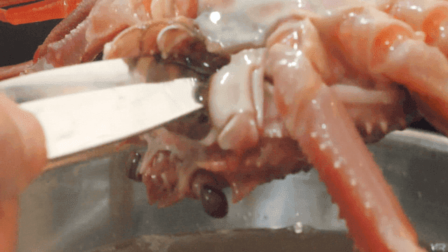 칼로 손질되는 게