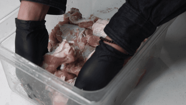 Marinating chicken pieces in a container