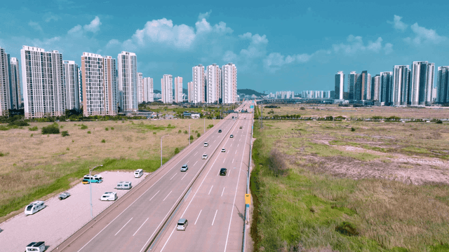 Highway leading to city with high-rise buildings