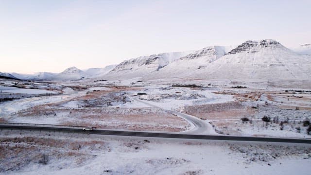 Snowy mountains and road with cars