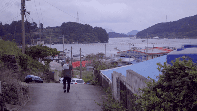 바다를 향해 마을 길을 걷는 남자 노인 