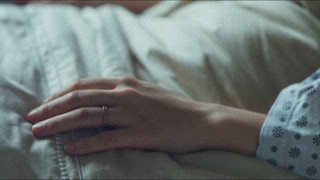 이불을 덮고 있는 환자의 손