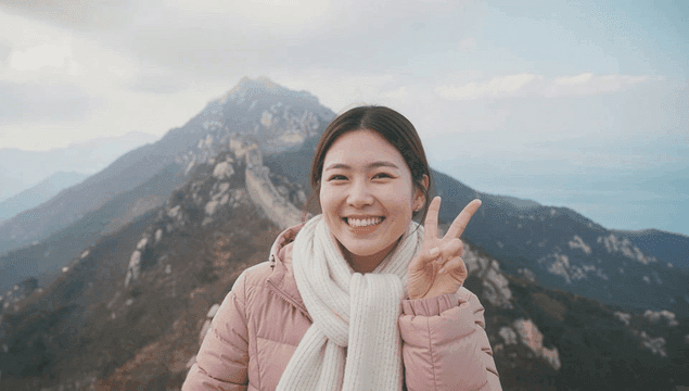 Smiling woman on top of mountain