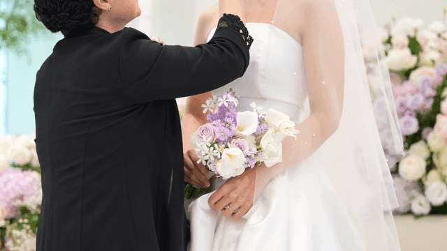 Bride and her assistant holding bouquet at wedding