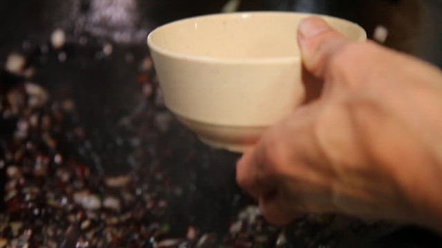 Ladle pouring Jjajang sauce into a bowl