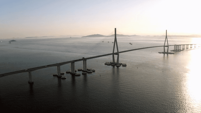 Long bridge over a calm sea at sunset