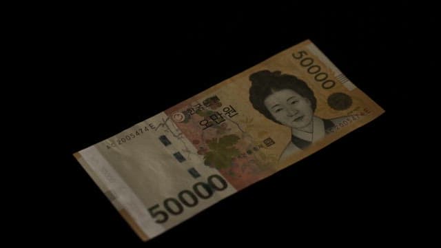 Fluorescent ink on a South Korean 50,000 won note under a UV lamp