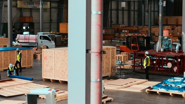 공장의 창고에서 목재 상품을 점검하는 작업자들