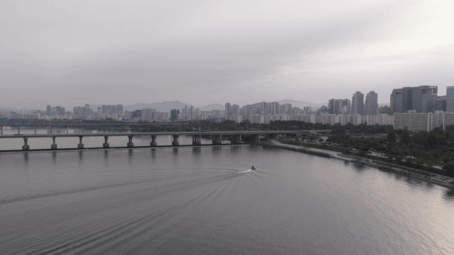Boat cruising on a river with city skyline
