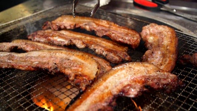 Close-up of Sizzling Pork Belly on a Grill