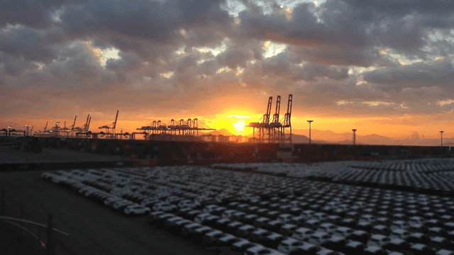 Sunset over a busy port with cranes