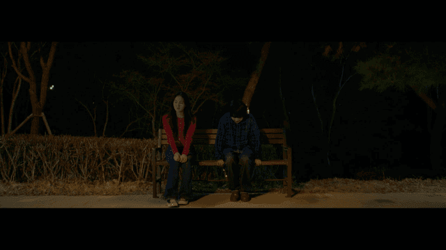 밤에 공원 벤치에 앉아 있는 커플