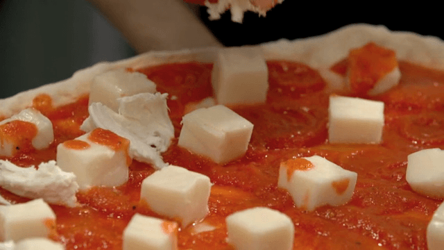 피자 도우 위에 모짜렐라 치즈를 올리는 손