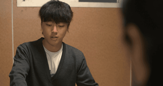 Young man speaking while looking down from room