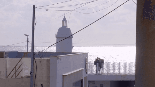 바다 옆 등대와 발코니에 있는 사람들