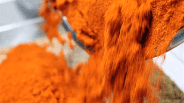 용기에 쏟아지는 붉은 고춧가루