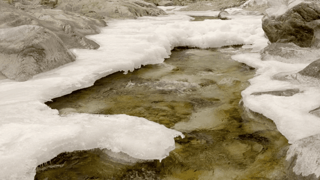 Flowing river with ice and rocks