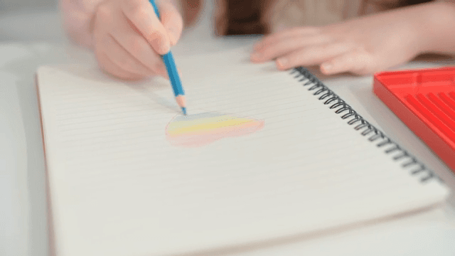 Child drawing with colored pencils