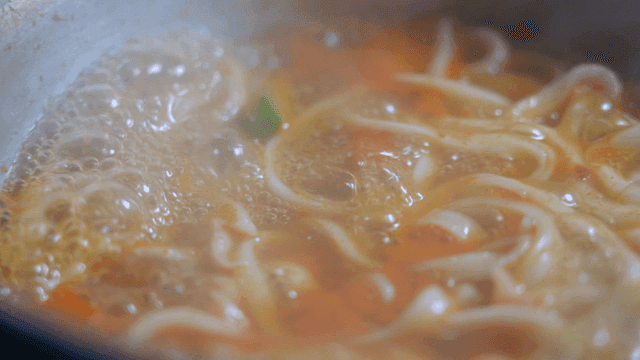 Kalguksu noodles boiling in spicy broth