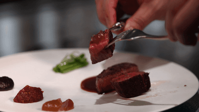 Steak eaten with sauce using knife and fork