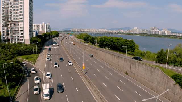 강과 도시 풍경 옆의 번잡한 고속도로