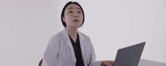 노트북으로 작업하는 가운을 입은 의사