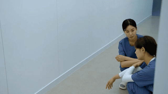 복도에서 동료를 위로하는 간호사