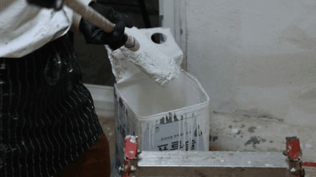 롤러에 페인트를 묻히는 사람