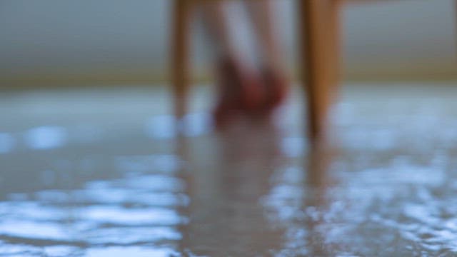 바닥 위 흐르는 물에 발을 담그고 있는 사람