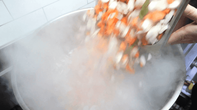 Sight of finely chopped vegetables being put into pot