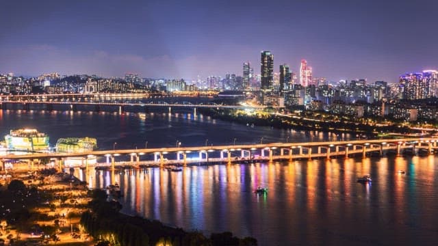 Night view of illuminated city skyline with water fountain