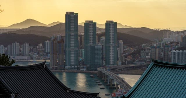 Evening view of a bustling port city with tall skyscrapers and bridge