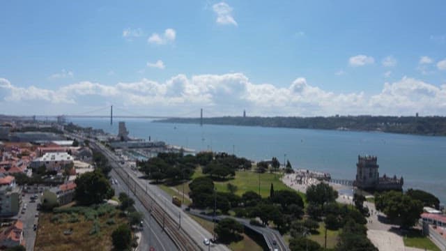 Riverside City with a Suspension Bridge Visible in the Distance on a Clear Day