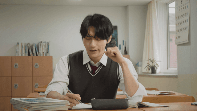 교실에서 피곤하게 하품하며 공부하는 학생