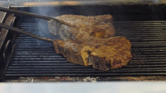 뜨거운 그릴 위에서 지글거리는 스테이크