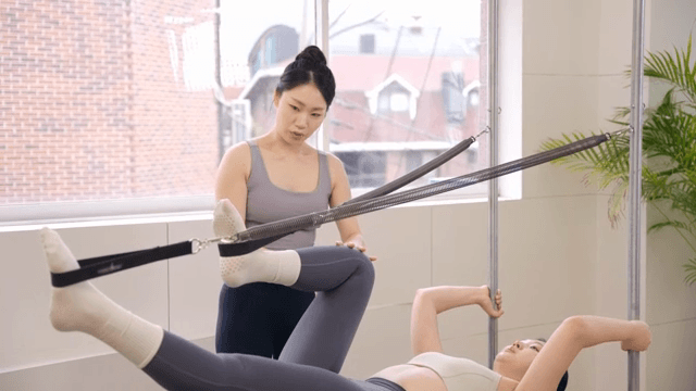 Pilates instructor guiding a student indoors