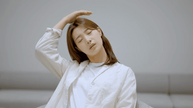 실내에서 목을 마사지하는 여성